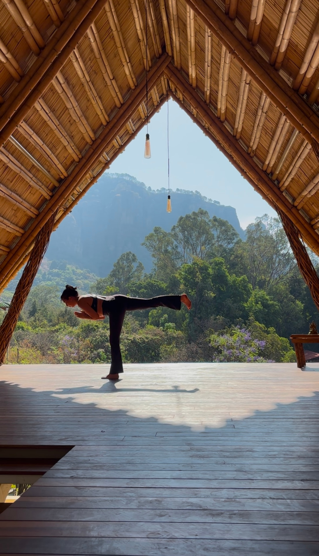 Standing balance practice on a wooden deck facing the mountains